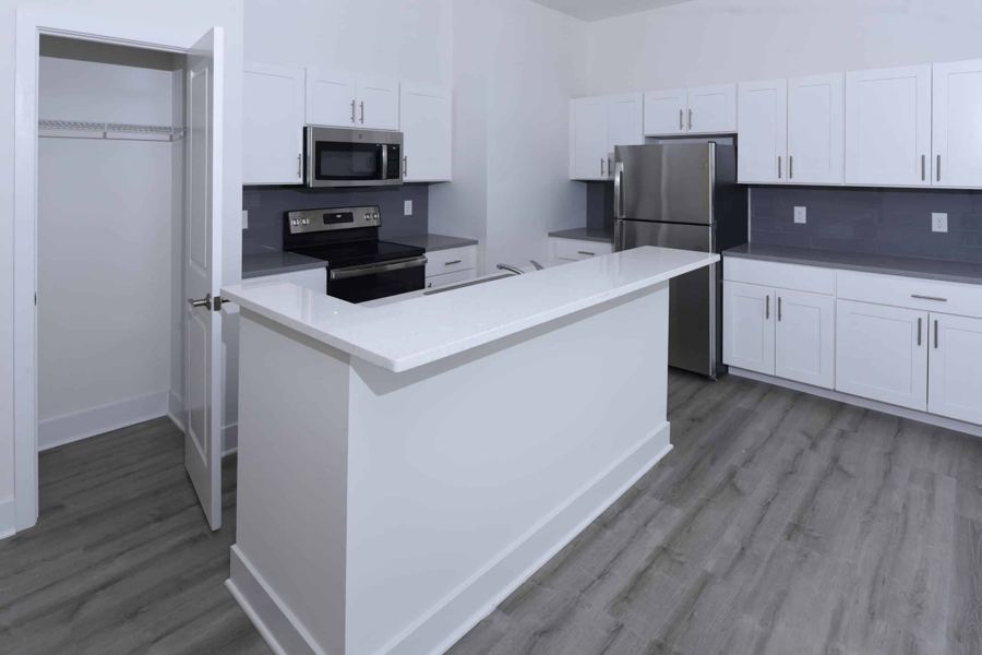 Kitchen island with white cabinetry and stainless appliances